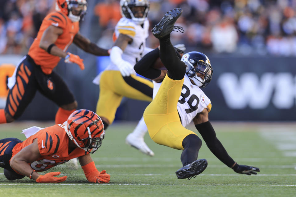 Pittsburgh Steelers free safety Minkah Fitzpatrick (39) is tripped by Cincinnati Bengals wide receiver Tyler Boyd (83) after making an interception during the first half of an NFL football game, Sunday, Nov. 28, 2021, in Cincinnati. (AP Photo/Aaron Doster)