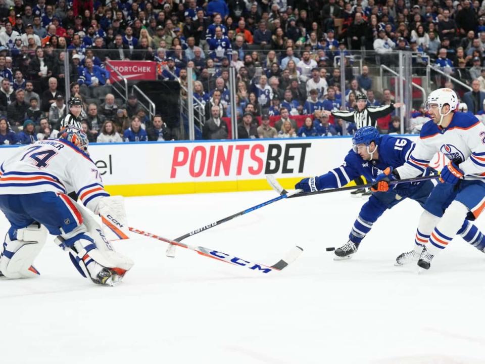 A PointsBet ad is seen in the background, as Alexander Kerfoot of the Toronto Maple Leafs battles two Edmonton players for control of the puck, in a photo taken during a hockey game at Toronto's Scotiabank Arena last month. PointsBet is among more than two dozen companies that are vying for sports betting business in Ontario's regulated market. (Nick Turchiaro/USA Today-Sports/Reuters - image credit)