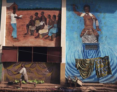 A displaced boy runs past a mural on the grounds of Saint Antoine de Padoue cathedral in Bossangoa, Central African Republic November 25, 2013. REUTERS/Joe Penney