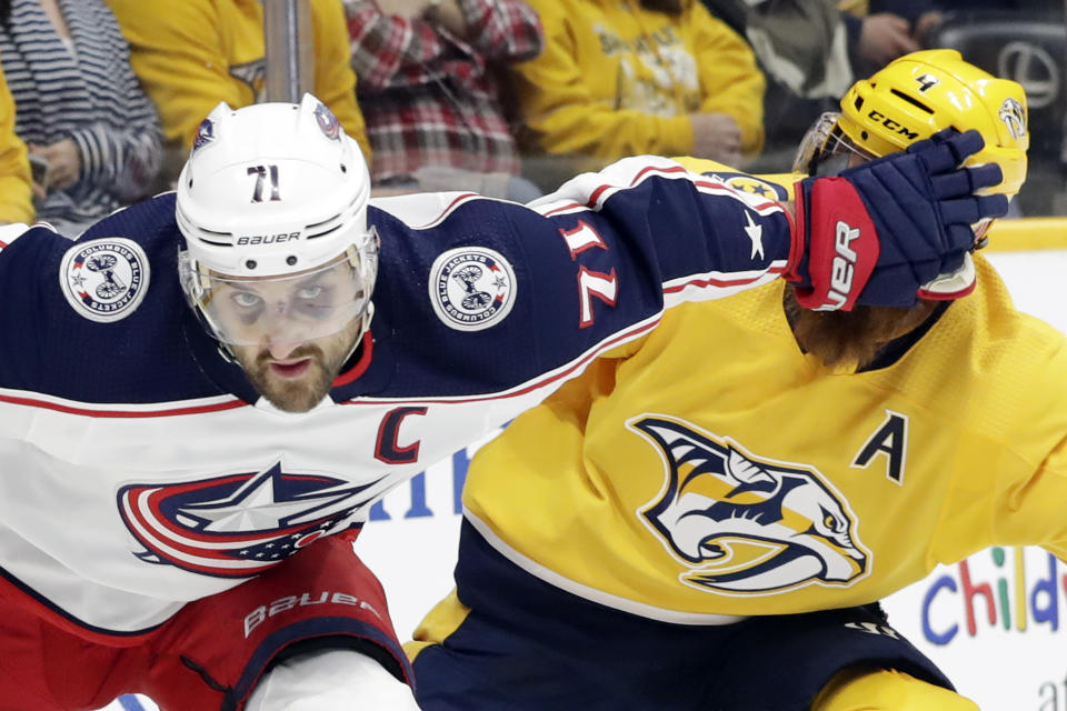 Columbus Blue Jackets left wing Nick Foligno (71) pushes his way past Nashville Predators defenseman Ryan Ellis (4) during the first period of an NHL hockey game Saturday, Feb. 22, 2020, in Nashville, Tenn. (AP Photo/Mark Humphrey)