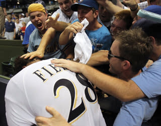 Fans of the Milwaukee Brewers embrace Prince Fielder after a win in Game 5 of the National League Division Series