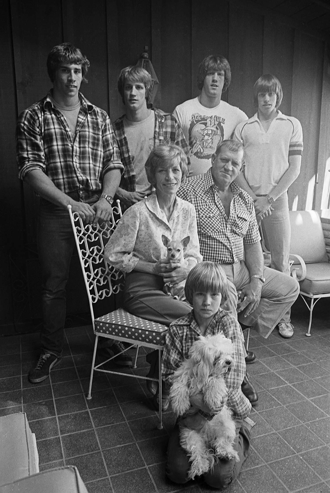March 15, 1980: Fritz Von Erich says the family “loves the heck out of each other.” Standing are Kerry, Kevin, David, and Mike; sitting are Doris and Fritz Von Erich, and Chris is kneeling. They are pictured in their home and two family dogs are seen in Doris’ and Chris’ laps.