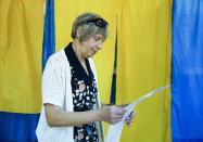 A woman holds her ballot at a polling station during a parliamentary election in Kiev, Ukraine, Sunday, July 21, 2019. The party of new President Volodymyr Zelenskiy is widely predicted to get the largest share of votes in Sunday‚Äôs election. (AP Photo/Evgeniy Maloletka)