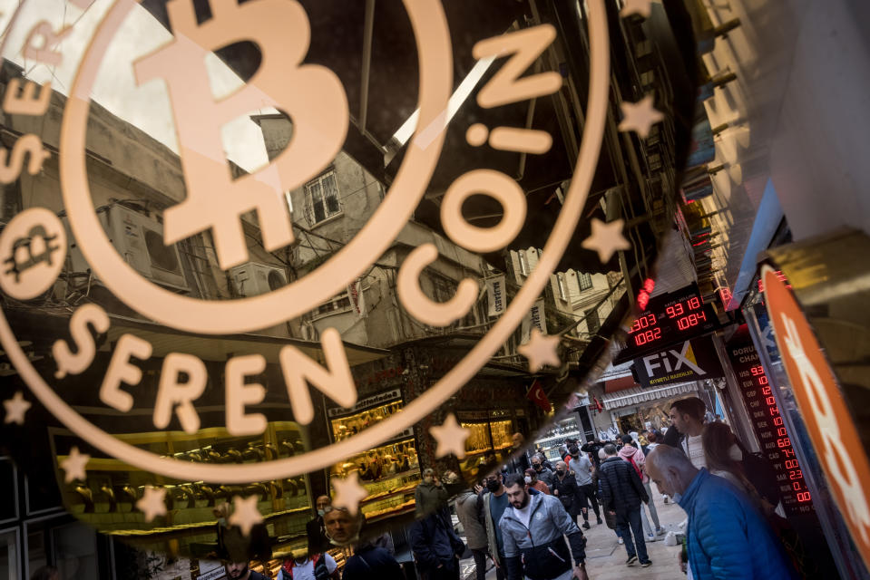 ISTANBUL, TURKEY - OCTOBER 19: People walk on the street underneath a Bitcoin exchange office sign on October 19, 2021 in Istanbul, Turkey. The number of Bitcoin and cryptocurrency exchanges have increased across Istanbul as cryptocurrency investing continues to boom in Turkey. Many investors see cryptocurrency's growth as a shelter against inflation and the depreciating Lira. Turkey's Lira has lost 20% of it's value this year as Bitcoin approaches it's all time high on the back of today's historic debut of the first Bitcoin futures ETF on the NYSE.  (Photo by Chris McGrath/Getty Images)