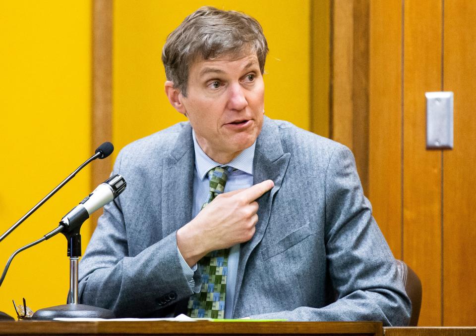 Testifying during the trial of Michael  Lang at the Hamilton County Courthouse on Thursday, Dr. Dennis Klein, a state medical examiner, gestures to where a bullet hit Iowa State Patrol Sgt. Jim Smith.