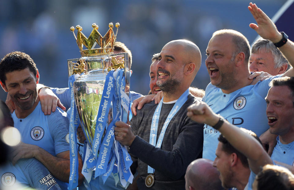 Manchester City coach Pep Guardiola lifts the English Premier League trophy after the English Premier League soccer match between Brighton and Manchester City at the AMEX Stadium in Brighton, England, Sunday, May 12, 2019. Manchester City defeated Brighton 4-1 to win the championship. (AP Photo/Frank Augstein)