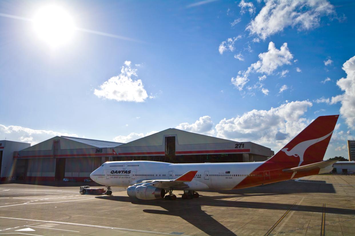 Qantas airplane being towed across the tarmac.