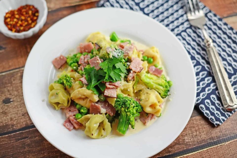 <p>This creamy dinner uses an easy Alfredo sauce recipe with cubed ham, peas, broccoli and seasonings to make a 20 minute one-pot meal!</p><p><strong>Get the recipe: <a href="https://www.savoryexperiments.com/creamy-tortellini-ham/" rel="nofollow noopener" target="_blank" data-ylk="slk:Creamy Ham and Cheese Tortellini;elm:context_link;itc:0;sec:content-canvas" class="link ">Creamy Ham and Cheese Tortellini</a></strong></p>