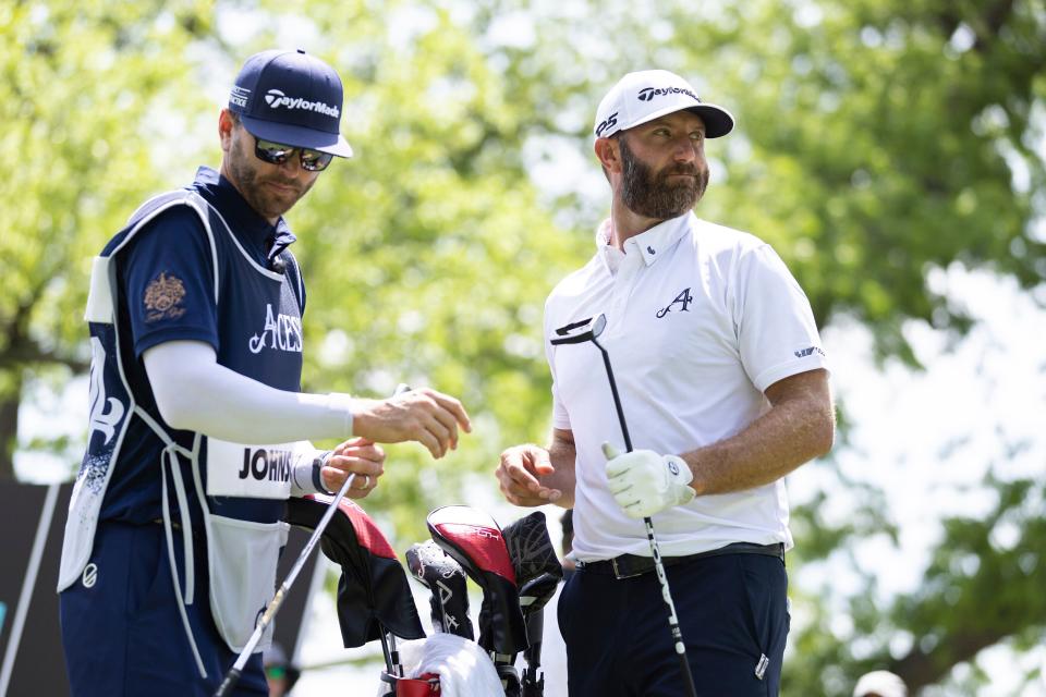 Dustin Johnson (right) watches a shot during the LIV Golf League event in Tulsa, Okla., on May 13.