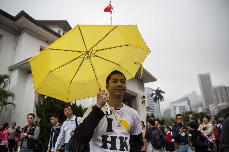A pro democracy protester raises his yellow umbrella, a symbol for the Umbrella Movement, at the annual open day for the Government House in Hong Kong on March 15, 2015