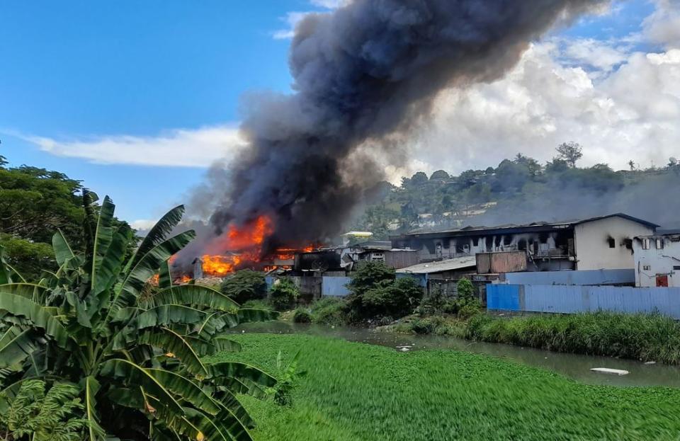 Flames rise from buildings in Honiara's Chinatown on November 26, 2021 as days of rioting have seen thousands ignore a government lockdown order, torching several buildings around the Chinatown district including commercial properties and a bank branch.<span class="copyright">Charley Piringi—AFP/Getty Images</span>