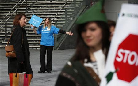 A guide directs shareholders to the Barclays AGM as protestors demonstrate in central London April 24, 2014. REUTERS/Suzanne Plunkett