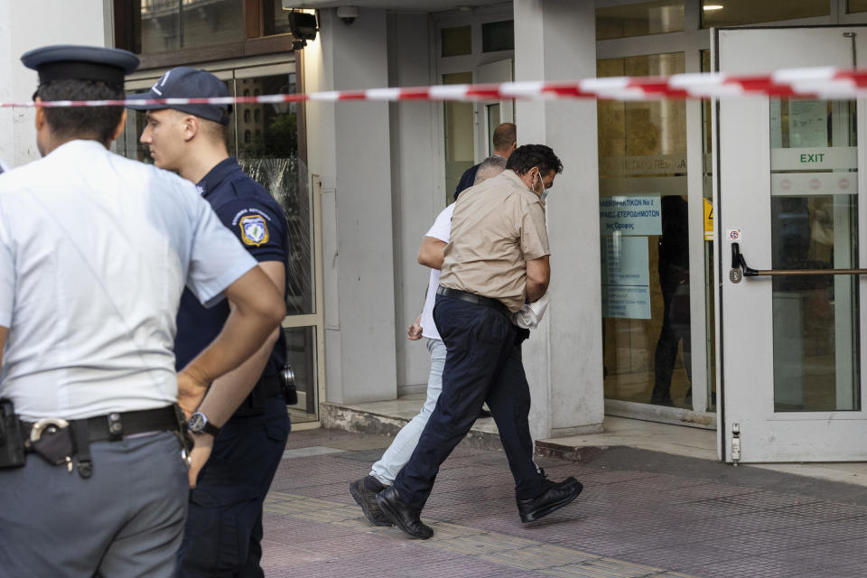 A defendant is transferred at a court house in Piraeus, near Athens, Greece, Saturday, Sept. 9, 2023. A Greek prosecutor has brought criminal charges against an island ferry captain and three of his crew over the death of a tardy passenger who was pushed by a crew member into the sea as he tried to board the departing vessel. (AP Photo/Yorgos Karahalis)