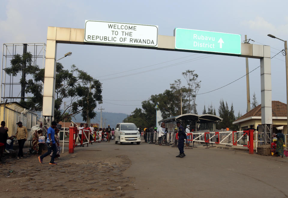 People walk past the Congo side of the Poids Lourd checkpoint at the border between Congo and Rwanda, Thursday, Aug. 1, 2019. Congo's presidency says the border is open again with Rwanda hours after its eastern neighbor closed it over the deadly Ebola outbreak. The closure occurred Thursday morning as the first case of direct transmission of the Ebola virus was confirmed in Goma, the Congo city of more than 2 million people on the Rwandan border.(AP Photo)