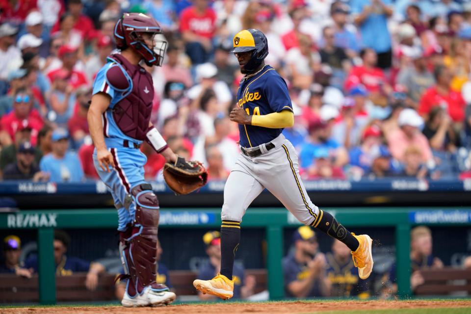 Milwaukee Brewers' Andruw Monasterio, right, scores past Philadelphia Phillies catcher Garrett Stubbs on a run-scoring single by William Contreras during the seventh inning of a baseball game, Thursday, July 20, 2023, in Philadelphia. (AP Photo/Matt Slocum)