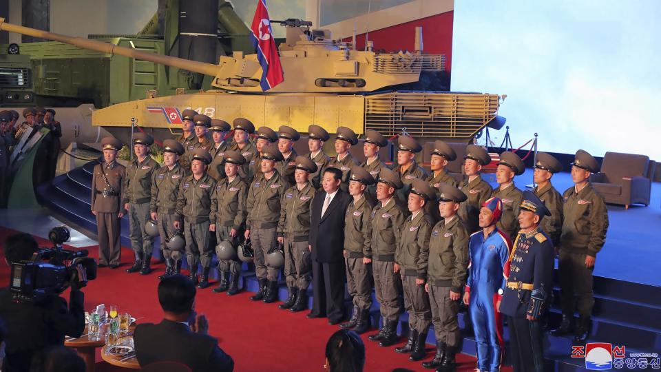 In this photo provided by the North Korean government, North Korean leader Kim Jong Un, center, poses for a group photo with fighter pilots who made the demonstration flight at the opening of an exhibition of weapons systems in Pyongyang, North Korea, Monday, Oct. 11, 2021. Kim reviewed the rare exhibition and vowed to build an “invincible” military, as he accused the United States of creating regional tensions and lacking action to prove it has no hostile intent toward the North, state media reported Tuesday. Independent journalists were not given access to cover the event depicted in this image distributed by the North Korean government. The content of this image is as provided and cannot be independently verified. Korean language watermark on image as provided by source reads: 