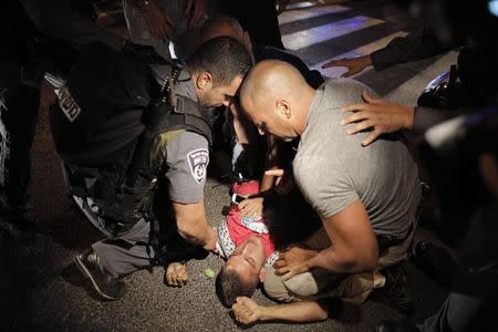 Israeli policemen detain an Arab-Israeli man during a protest against the Israeli offensive on the Gaza Strip, in the northern city of Haifa July 19, 2014. REUTERS/Ammar Awad