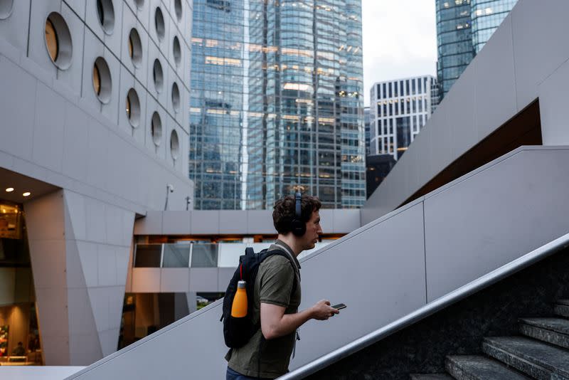 A man walks past a pedestrian footbridge in the financial central district of Hong Kong