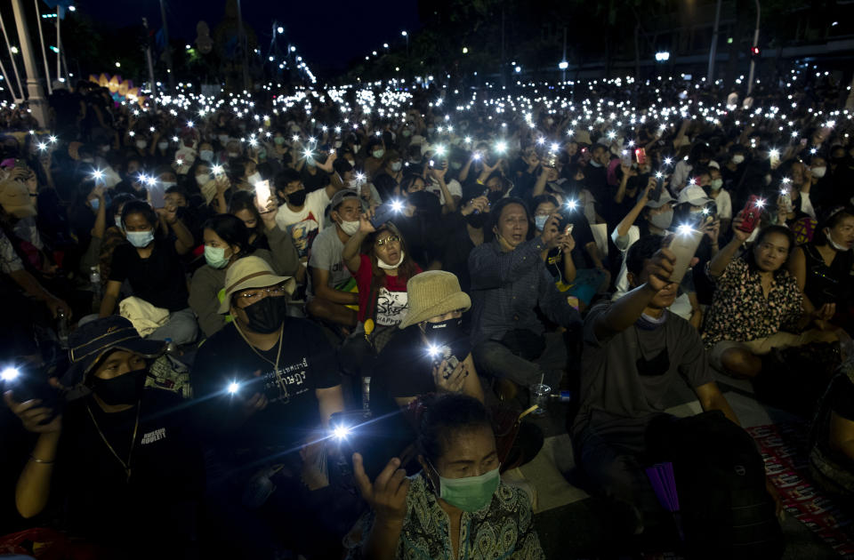 Pro-democracy activities display mobile phones with flash lights on during a protest at Democracy Monument in Bangkok, Thailand, Sunday, Aug, 16, 2020. Protesters have stepped up pressure on the government demanding to dissolve the parliament, hold new elections, amend the constitution and end intimidation of the government's opponents. (AP Photo/Gemunu Amarasinghe)