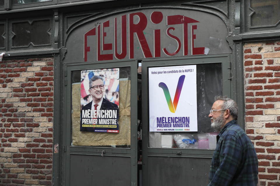 A man walks past election posters reading "Melenchon Prime Minister" for the alliance of leftist parties cobbled together by hard-left leader Jean-Luc Melenchon, Friday, June 10, 2022 in Lille, northern France. Leftist parties that had nearly disappeared from the French political landscape have grown wings in the run-up to Sunday's legislative elections and now threaten to weaken French President Emmanuel Macron (AP Photo/Michel Spingler)