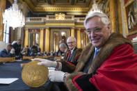 A 15-kilogram (33-pound) gold coin produced to celebrate the late Queen Elizabeth II's Platinum Jubilee, is assessed during the "Trial of the Pyx,'' a ceremony that dates to the 12th Century in which coins are weighed in order to make certain they are up to standard, at the Goldsmiths' Hall in London, Tuesday, Feb. 7, 2023. A jury sat solemnly in a gilded hall in central London on Tuesday, presided over by a bewigged representative of the crown in flowing black robes, but there were no criminals in the dock. (AP Photo/Kin Cheung)