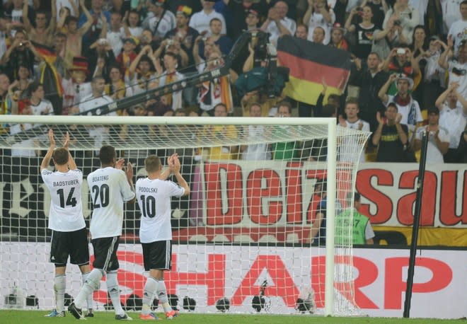 German defender Holger Badstuber (L) German defender Jerome Boateng(2ndL) and German forward Lukas Podolski applaud their fans at the end of the Euro 2012 championships football match Germany vs Portugal on June 9, 2012 at the Arena Lviv. Germany won 1-0. AFP PHOTO / JEFF PACHOUDJEFF PACHOUD/AFP/GettyImages