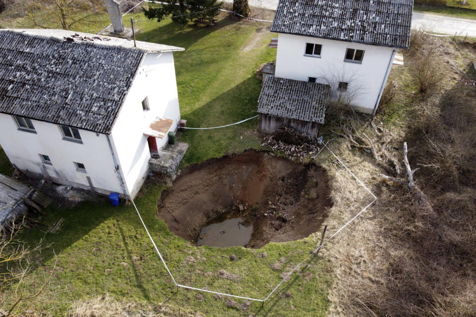 This aerial photo shows a sinkhole in the village of Mececani, central Croatia, Thursday, March 4, 2021. A central Croatian region about 40 kilometers (25 miles) southwest of the capital Zagreb is pocked with round holes of all sizes, which appeared after December's 6.4-magnitude quake that killed seven people and caused widespread destruction. Scientists have been flocking to Mecencani and other villages in the sparsely-inhabited region for observation and study. (AP Photo/Darko Bandic)