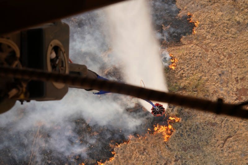 Two Hawaii Army National Guard CH47 Chinook perform aerial water bucket drops in Maui to assist in the fight against wildfires, across the Island of Maui, Hawaii, on Wednesday. Photo by MSgt. Andrew Jackson/USAF/U.S. National Guard/UPI