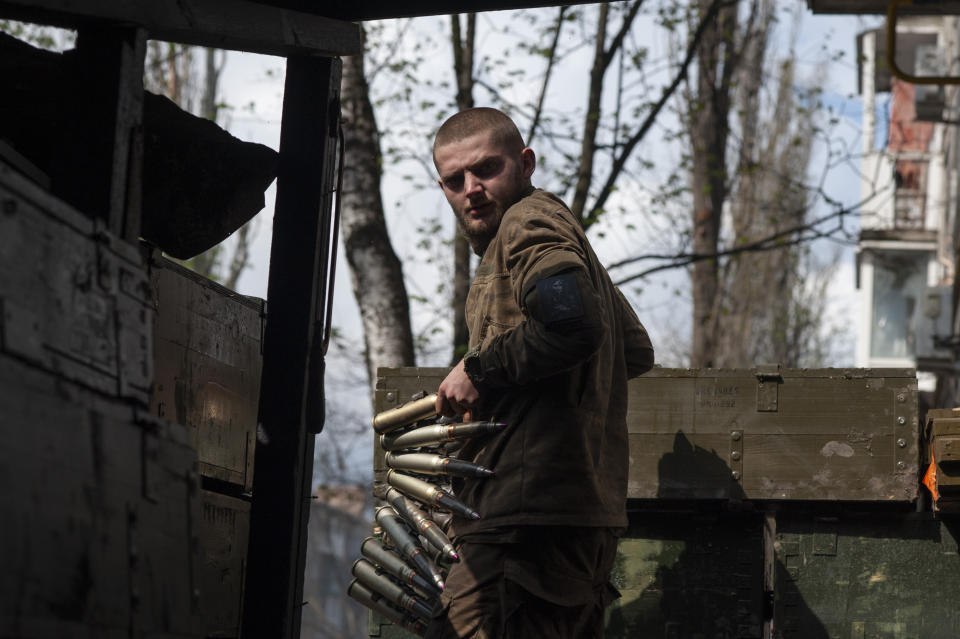 FILE - A Ukrainian soldier carries cartridges in war-hit Bakhmut, Donetsk region, Ukraine, Sunday, April 23, 2023. Ukrainian President Volodymyr Zelenskyy said Sunday, May 21, 2023 that Russian forces weren't occupying Bakhmut, casting doubt on Moscow's insistence that the eastern Ukrainian city had fallen. The fog of war made it impossible to confirm the situation on the ground in the invasion’s longest battle, and the comments from Ukrainian and Russian officials added confusion to the matter. (Iryna Rybakova via AP, File)