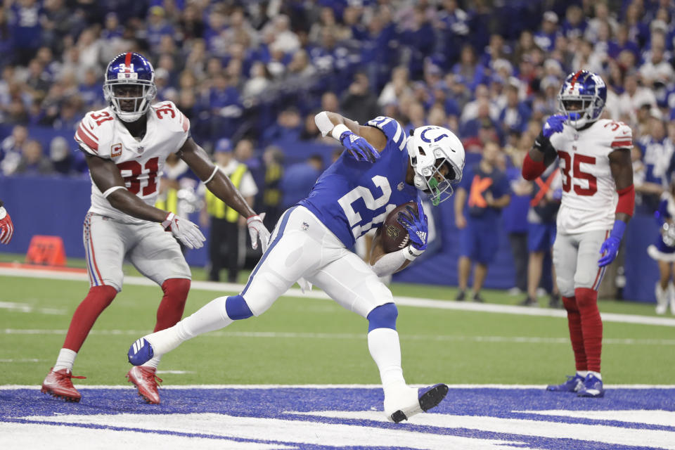 Indianapolis Colts running back Nyheim Hines (21) runs in for a touchdown in front of New York Giants defensive back Michael Thomas (31) during the first half of an NFL football game in Indianapolis, Sunday, Dec. 23, 2018. (AP Photo/Darron Cummings)