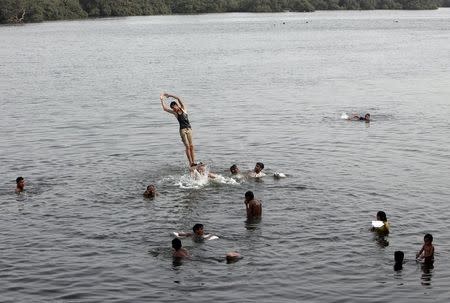 Men and children cool off during intense hot weather at China Creek in Karachi, Pakistan, June 22, 2015. REUTERS/Akhtar Soomro