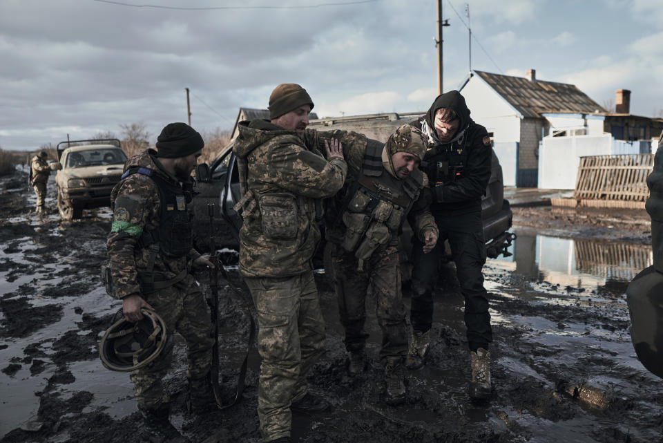 FILE - Ukrainian soldiers help a wounded comrade into an evacuation vehicle in the frontline in Bakhmut, Donetsk region, Ukraine, on Feb. 20, 2023. Two years after Russia’s full-scale invasion captured nearly a quarter of the country, the stakes could not be higher for Kyiv. After a string of victories in the first year of the war, fortunes have turned for the Ukrainian military, which is dug in, outgunned and outnumbered against a more powerful opponent. (AP Photo/Libkos, File)