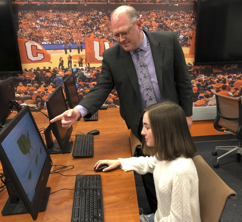 This undated photo provided by Syracuse University Falk College shows Rodney Paul, director of the sport analytics program, in the lab working with Bailie Brown, at the David B. Falk College of Sport and Human Dynamics at Syracuse University, in Syracuse, N.Y. Brown will graduate in May 2021 with a Bachelor of Science degree in sport analytics, becoming the first woman to complete the four-year undergraduate program since its inception five years earlier. Her 23 classmates are men. (Margie Chetney/Syracuse University Falk College via AP)