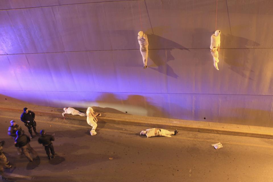 Christopher Vanegas, a Mexican photographer working for La Vanguardia / El Guardian won the 3rd Prize Contemporary Issues Single category of the 2014 World Press Photo contest with this picture of police arriving at a crime scene where two bodies hang from a bridge; another three are on the floor in Saltillo, Coahuila, Mexico, taken March 8, 2013. REUTERS/Christopher Vanegas/World Press Photo Handout via Reuters