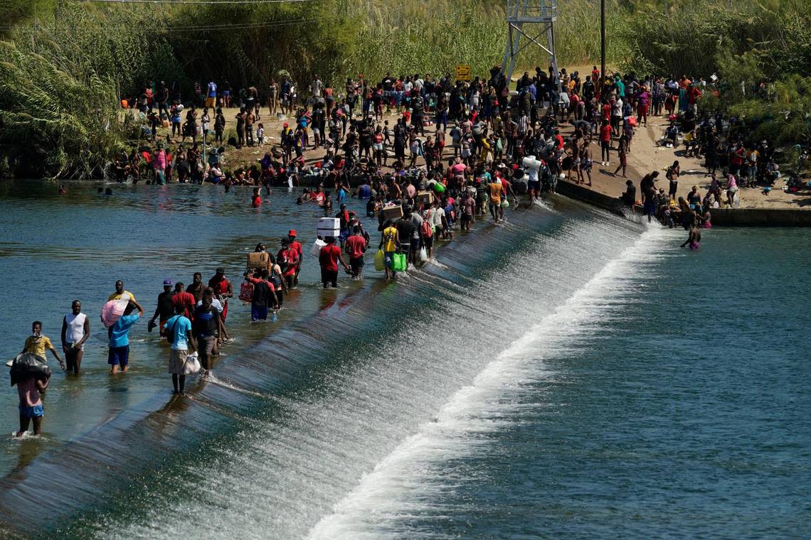 Haitian migrants use a dam to cross to and from the United States from Mexico, Friday, Sept. 17, 2021, in Del Rio, Texas. Thousands of Haitian migrants have assembled under and around a bridge in Del Rio presenting the Biden administration with a fresh and immediate challenge as it tries to manage large numbers of asylum-seekers who have been reaching U.S. soil.