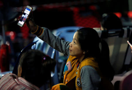 A family member shows a photo of a kid near Tham Luang cave complex, as members of under-16 soccer team and their coach have been found alive according to a local media's report in the northern province of Chiang Rai, Thailand, July 3, 2018. REUTERS/Soe Zeya Tun