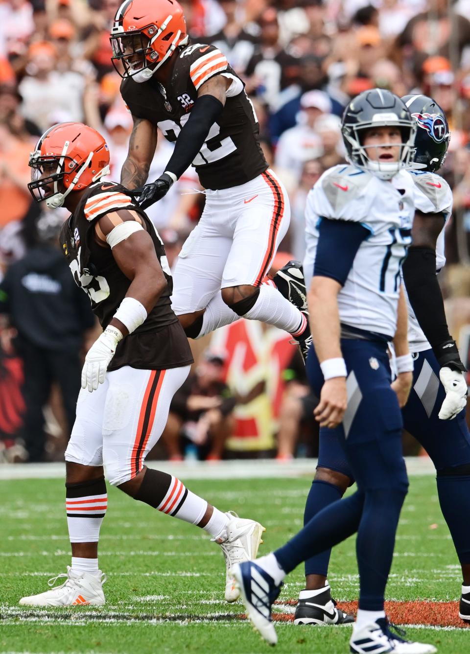 Cleveland Browns safety Grant Delpit (22) and defensive end Myles Garrett (95) celebrate as Tennessee Titans quarterback Ryan Tannehill (17) walks off the field Sept. 24 in Cleveland.