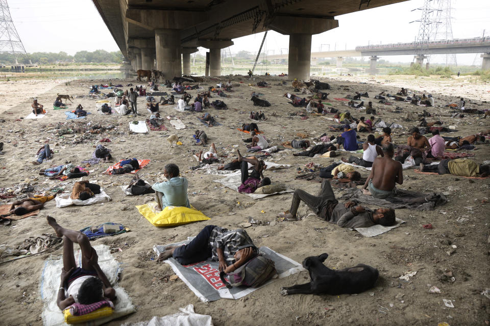 FILE - Homeless people sleep in the shade of a bridge on a hot day in New Delhi, Friday, May 20, 2022. Commonwealth leaders are set to adopt the much-awaited “Living Lands Charter”, an action plan to address climate change, land degradation and biodiversity loss. Recent weather events and longer term climate trends, including heatwaves, extreme temperatures, drought, cyclones, floods and sea-level rise, afflict most of its member states. (AP Photo/Manish Swarup, File)