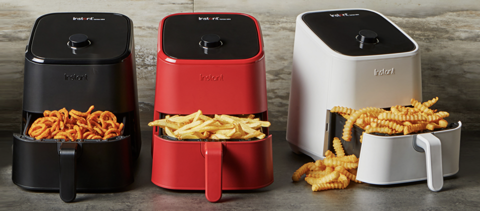 Three instant vortex mini air fryers side by side containing onion rings, fries and crinkle cut chips