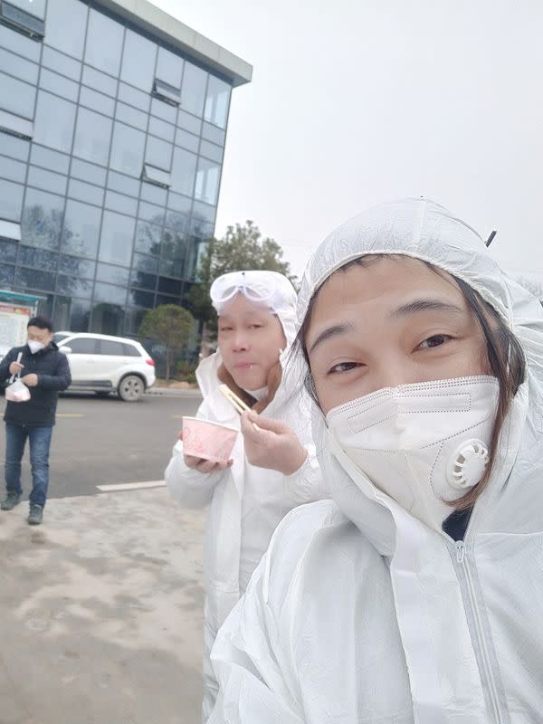 Wuhan resident Chen Hui poses for a selfie in protective suit with another volunteer as they deliver meat and vegetables to construction workers building a temporary hospital in Ezhou