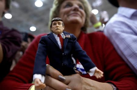 A supporter of Republican U.S. presidential nominee Donald Trump holds a Trump doll as she listens to Trump speak at a campaign rally in Ambridge, Pennsylvania, October 10, 2016. REUTERS/Mike Segar