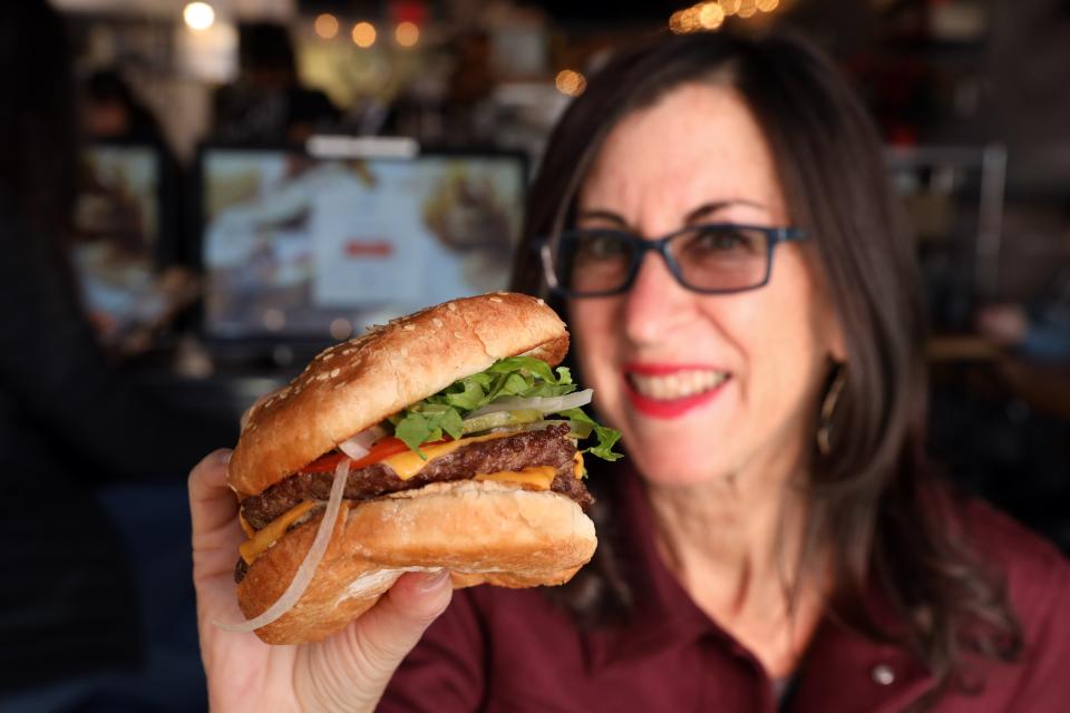 Lohud food reporter Jeanne Muchnick tries the Mason burger, which is two four oz. house blend patties, lettuce, tomato, onion, cheese and special sauce at Mason Sandwich Co. in Eastchester Nov. 30, 2023.