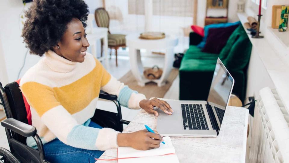 Young black woman in a wheelchair working online from home