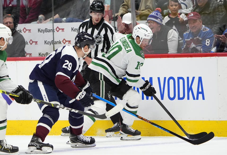 Colorado Avalanche center Nathan MacKinnon, left, pursues the puck with Dallas Stars center Ty Dellandrea in the second period of an NHL hockey game Tuesday, Feb. 27, 2024, in Denver. (AP Photo/David Zalubowski)