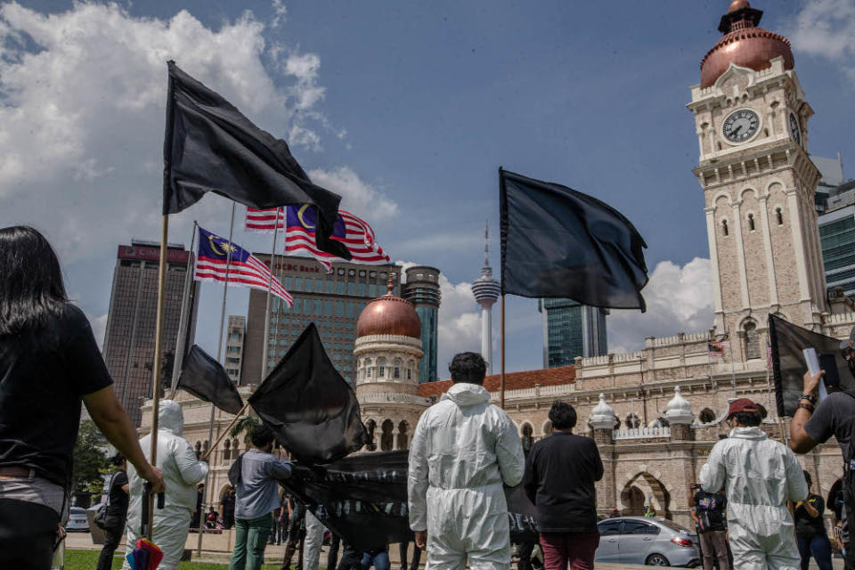 A group of youth wearing black shirts and personal protection equipment wave black flags during a protest at Dataran Merdeka in Kuala Lumpur July 17, 2021. — Picture by Firdaus Latif