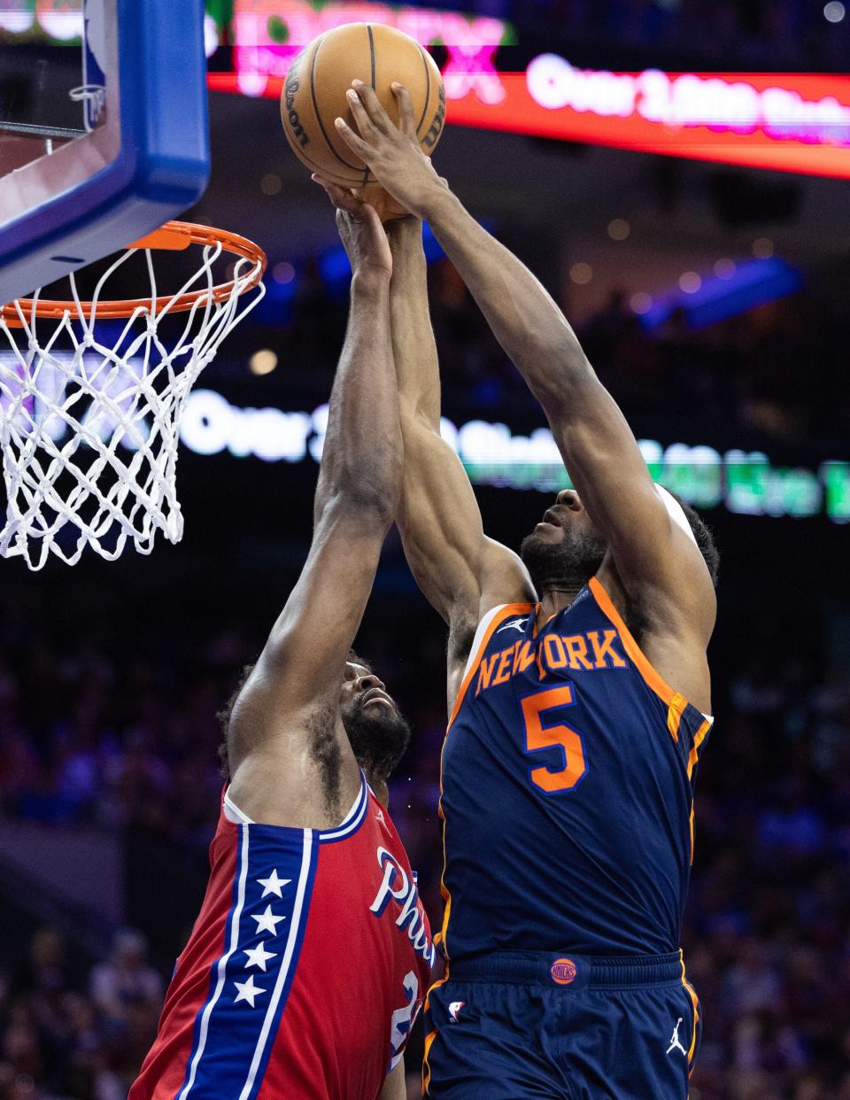 Apr 28, 2024; Philadelphia, Pennsylvania, USA; Philadelphia 76ers center Joel Embiid (21) blocks the drive of New York Knicks forward Precious Achiuwa (5) during the second half of game four of the first round in the 2024 NBA playoffs at Wells Fargo Center. Mandatory Credit: Bill Streicher-USA TODAY Sports