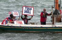 Royal supporters wearing costumes and displaying placards can be seen aboard a vintage boat after Britain's Prince William and his wife Catherine, the Duchess of Cambridge, sailed aboard two America's Cup yachts on Auckland Harbour April 11, 2014. Britain's Prince William and his wife Kate are undertaking a 19-day official visit to New Zealand and Australia with their son George. REUTERS/Phil Noble (NEW ZEALAND - Tags: ROYALS)