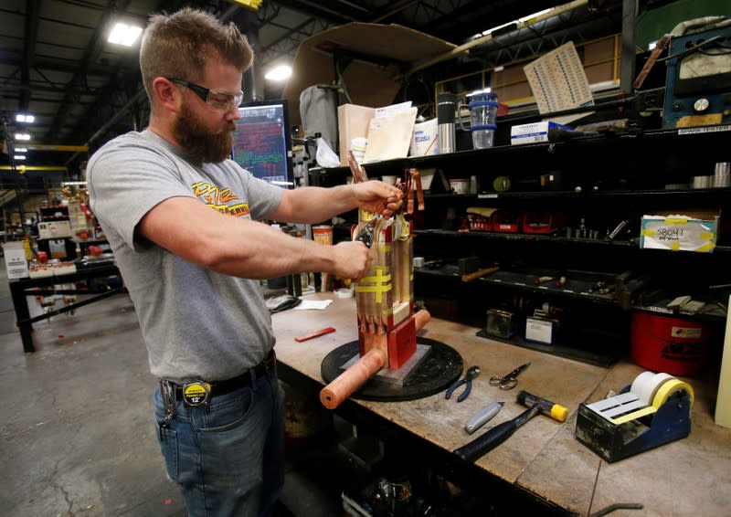 FILE PHOTO: Sub-assembly worker Joel Dykema works on the sub-assembly of a transformer in the RoMan Manufacturing plant in Grand Rapids, Michigan