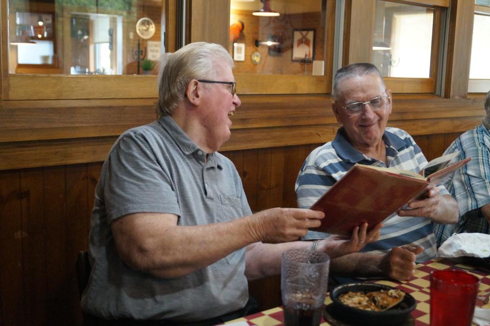 Bill Glass and Leonard Walton share a laugh while looking at the 1961 Hillsdale High School yearbook.