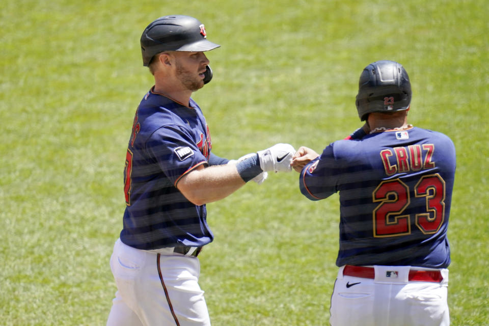 Minnesota Twins' Ryan Jeffers, left, and Nelson Cruz fist bump after Jeffers' two-run home run off Cincinnati Reds' pitcher Wade Miley in the fourth inning of a baseball game, Tuesday, June 22, 2021, in Minneapolis. (AP Photo/Jim Mone)
